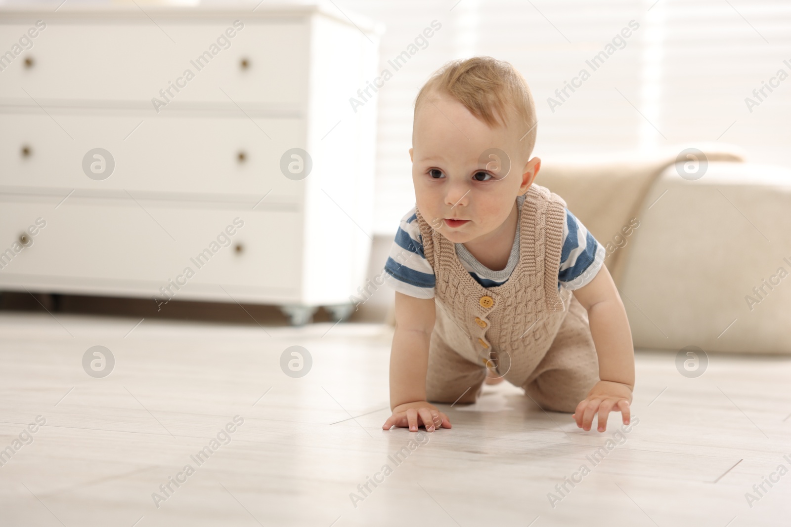 Cute little baby crawling on floor at home, space for text Photo of Cute little baby crawling on floor at home, space for text