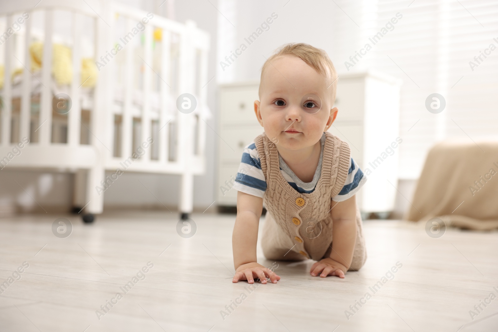 Cute little baby crawling on floor at home, space for text Photo of Cute little baby crawling on floor at home, space for text