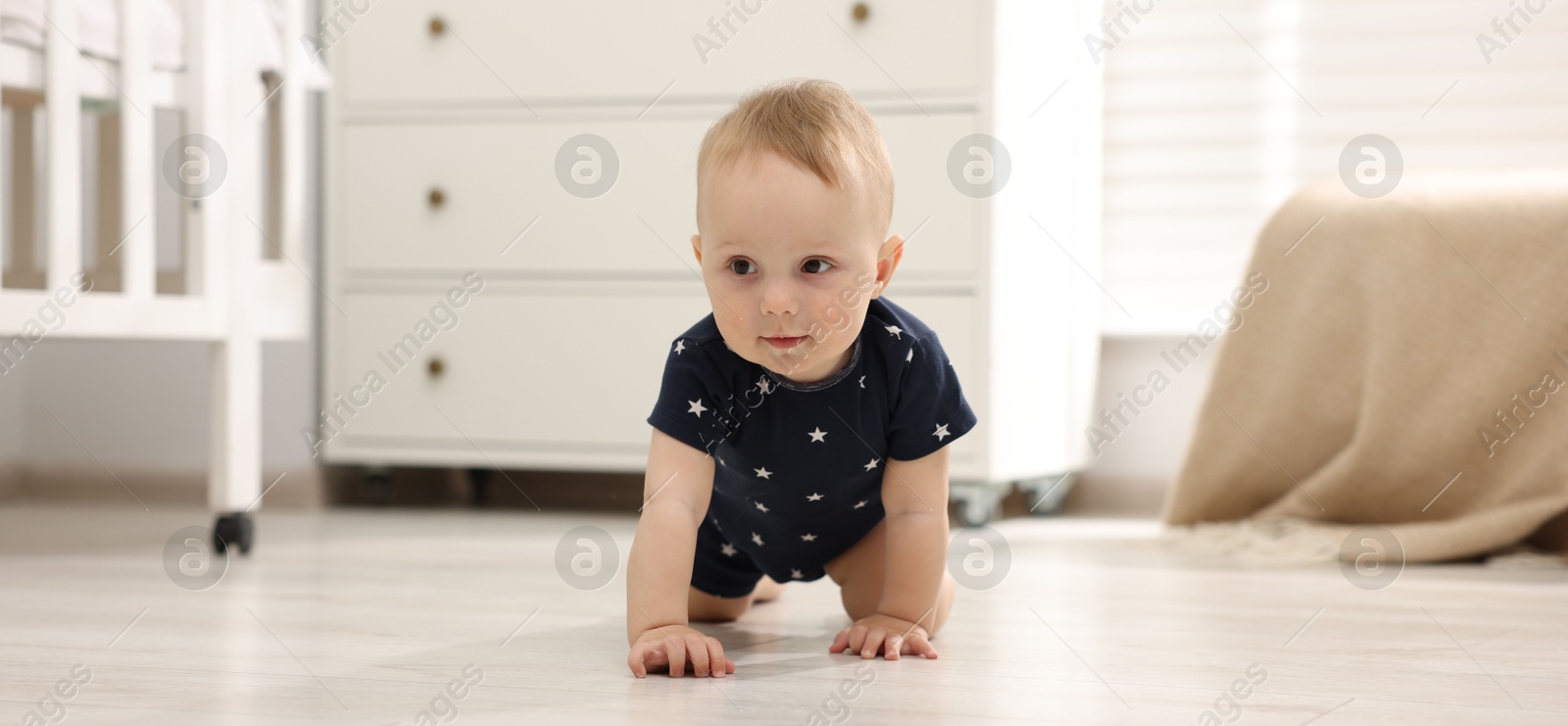 Cute little baby crawling on floor at home Photo of Cute little baby crawling on floor at home