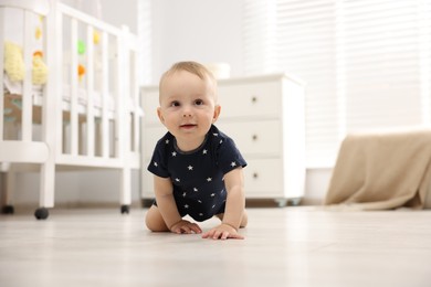 Photo of Cute little baby crawling on floor at home