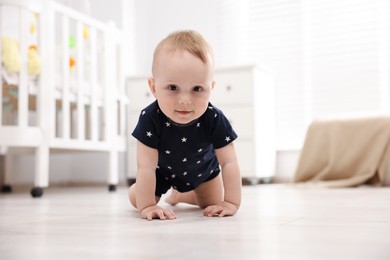 Photo of Cute little baby crawling on floor at home