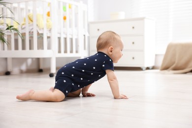 Photo of Cute little baby crawling on floor at home