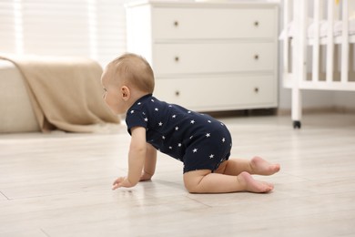 Photo of Cute little baby crawling on floor at home