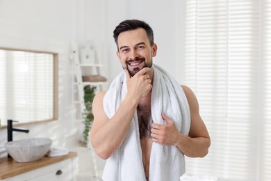 Photo of Portrait of smiling man before shaving in bathroom