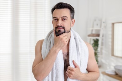 Photo of Portrait of handsome man before shaving in bathroom