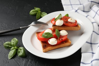 Photo of Tasty sandwiches with mozzarella cheese, tomatoes and basil on dark textured table, closeup