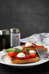 Photo of Tasty sandwiches with mozzarella cheese, tomatoes and basil on dark table against grey background, closeup