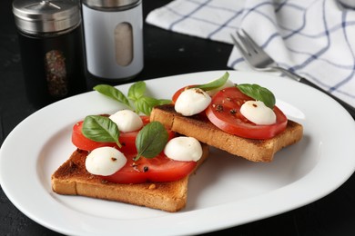 Photo of Tasty sandwiches with mozzarella cheese, tomatoes and basil on dark table, closeup