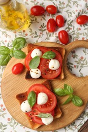 Photo of Tasty sandwiches with mozzarella cheese, tomatoes and basil on table, flat lay