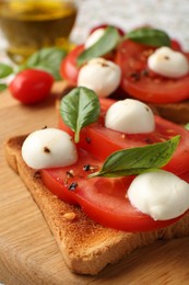 Photo of Tasty sandwiches with mozzarella cheese, tomatoes and basil on table, closeup