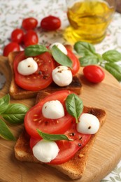 Photo of Tasty sandwiches with mozzarella cheese, tomatoes and basil on tablecloth, closeup