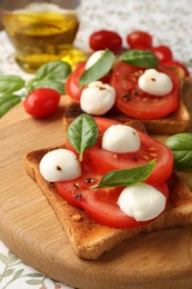 Photo of Tasty sandwiches with mozzarella cheese, tomatoes and basil on tablecloth, closeup