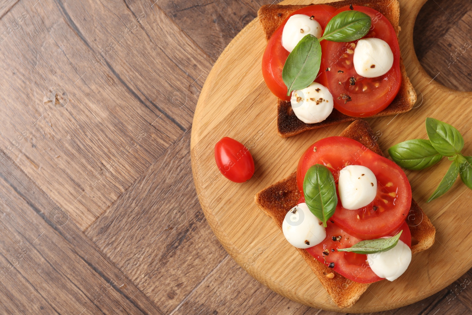 Tasty sandwiches with mozzarella cheese, tomatoes and basil on wooden table, top view. Space for text Photo of Tasty sandwiches with mozzarella cheese, tomatoes and basil on wooden table, top view. Space for text