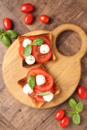 Photo of Tasty sandwiches with mozzarella cheese, tomatoes and basil on wooden table, flat lay