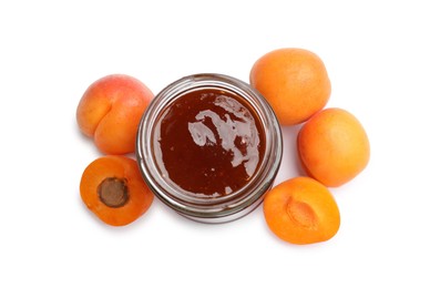Photo of Sweet jam in jar and apricots isolated on white, top view
