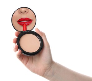 Image of Beautiful woman looking in compact powder mirror while applying red lipstick on white background, closeup