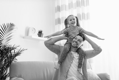 Image of Dad with his daughter having fun at home. Black-and-white toning