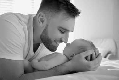 Image of Dad with his baby daughter at home. Black-and-white toning