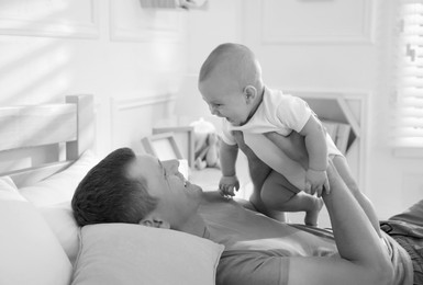 Image of Dad with his baby daughter at home. Black-and-white toning