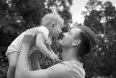 Image of Dad with his baby daughter outdoors. Black-and-white toning