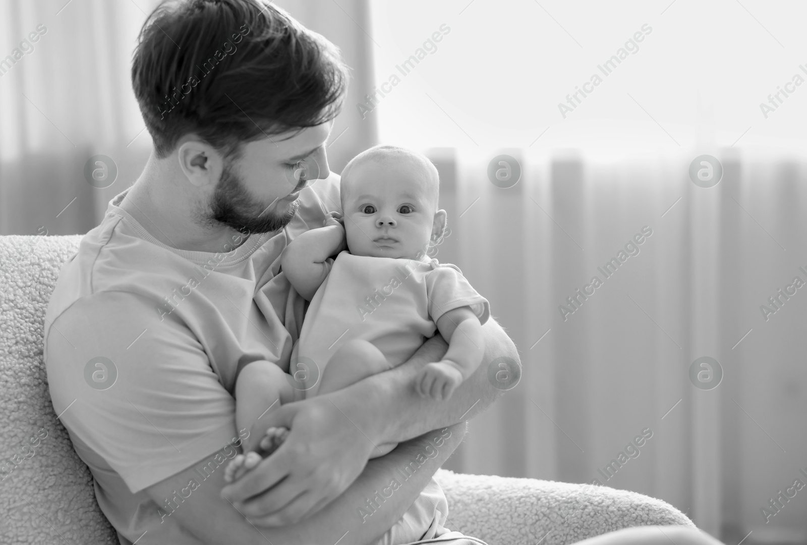 Dad with his baby daughter at home. Black-and-white toning Image of Dad with his baby daughter at home. Black-and-white toning