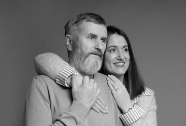Image of Dad with his grown-up daughter on grey background. Black-and-white toning