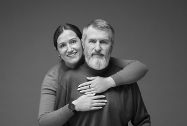 Image of Dad with his grown-up daughter on grey background. Black-and-white toning