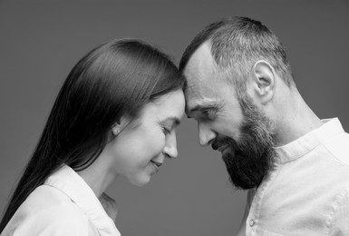 Image of Dad with his grown-up daughter on grey background. Black-and-white toning