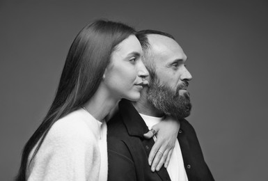 Image of Dad with his grown-up daughter on grey background. Black-and-white toning