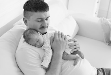 Image of Dad holding his baby daughter at home. Black-and-white toning