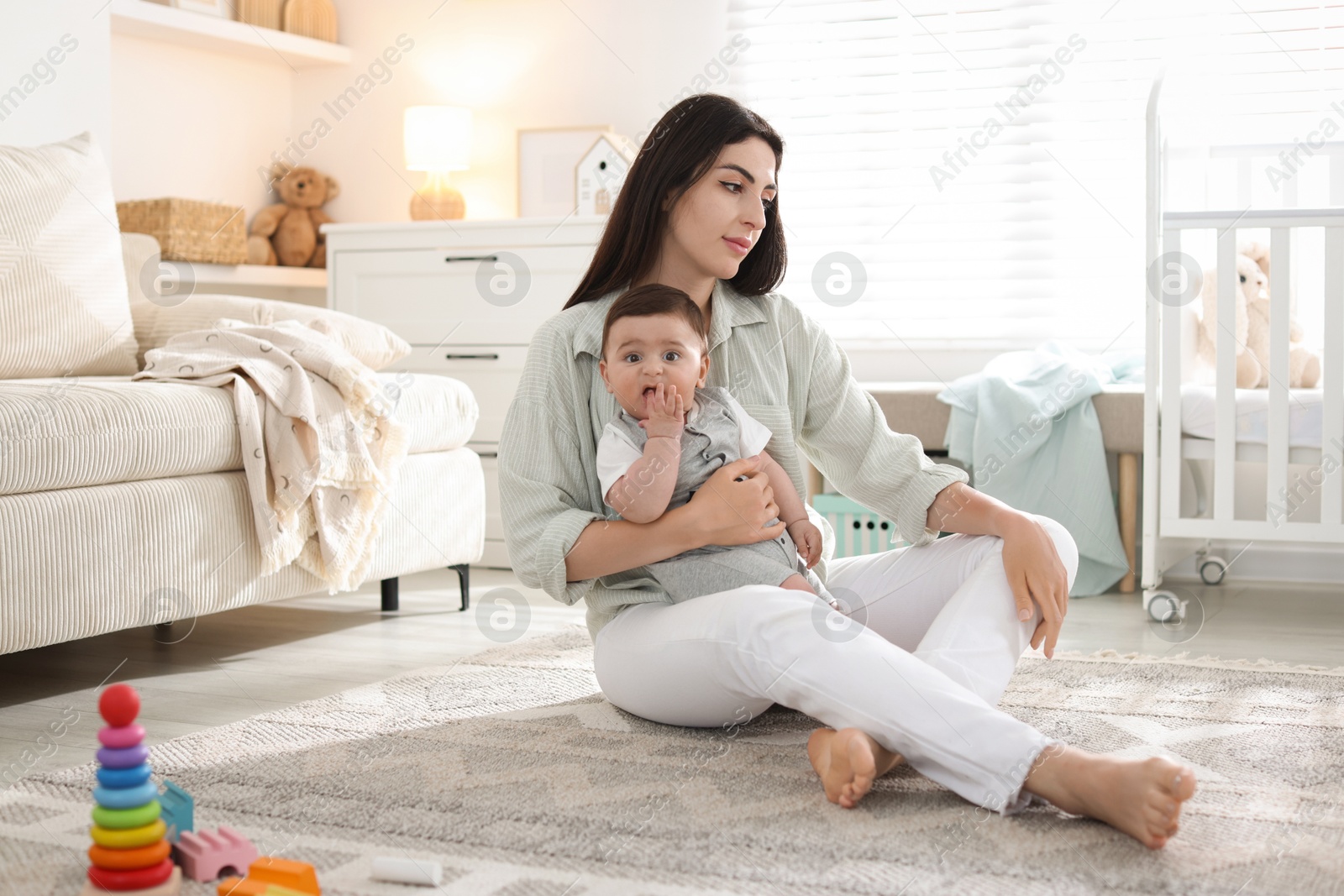 Woman suffering from postpartum depression with her little baby at home Photo of Woman suffering from postpartum depression with her little baby at home