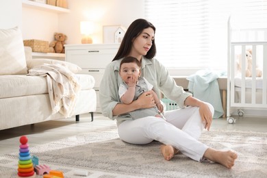 Photo of Woman suffering from postpartum depression with her little baby at home
