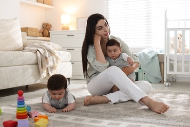 Photo of Woman suffering from postpartum depression with her little children at home