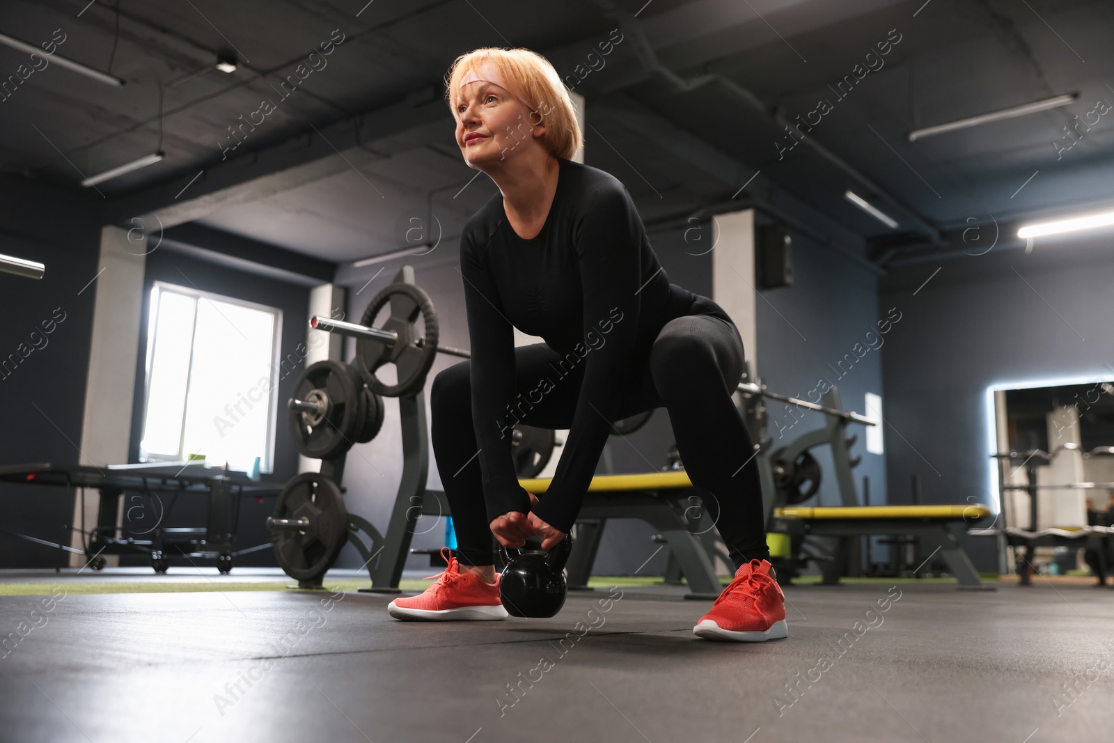 Senior woman training with kettlebell in gym, low angle view Photo of Senior woman training with kettlebell in gym, low angle view
