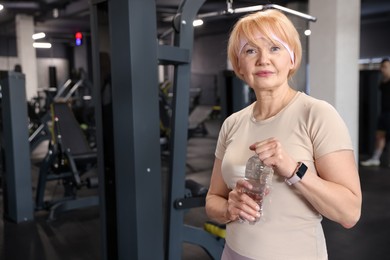 Photo of Senior woman with bottle of water in gym