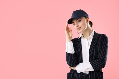 Photo of Portrait of beautiful woman in stylish baseball hat on pink background. Space for text