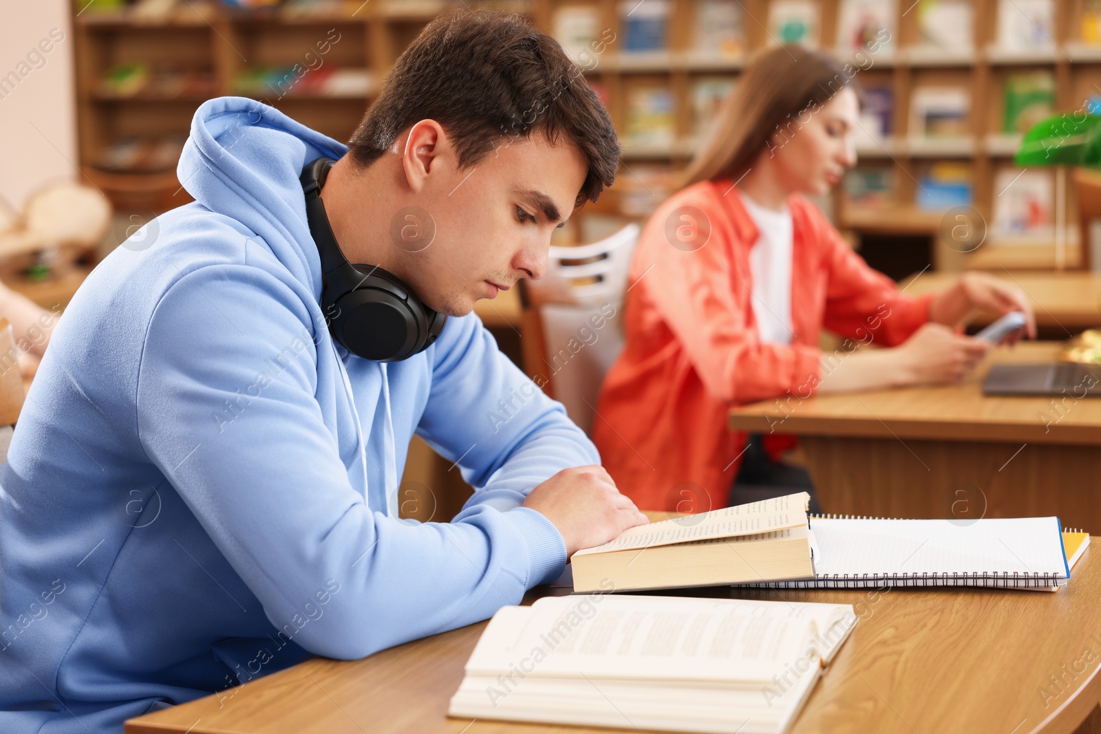 People studying at desks in public library, selective focus Photo of People studying at desks in public library, selective focus