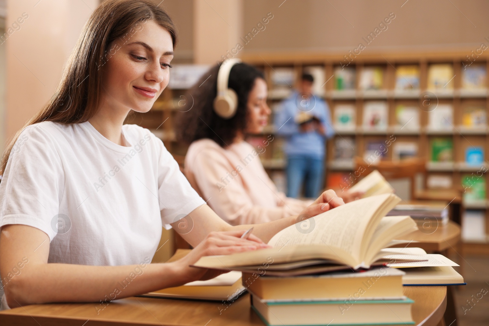Photo of People studying at desks in public library, selective focus