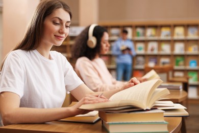 Photo of People studying at desks in public library, selective focus