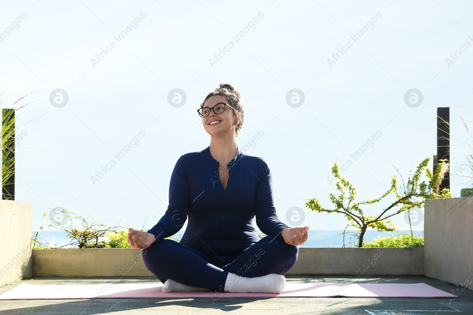 Woman meditating on yoga mat at balcony Photo of Woman meditating on yoga mat at balcony