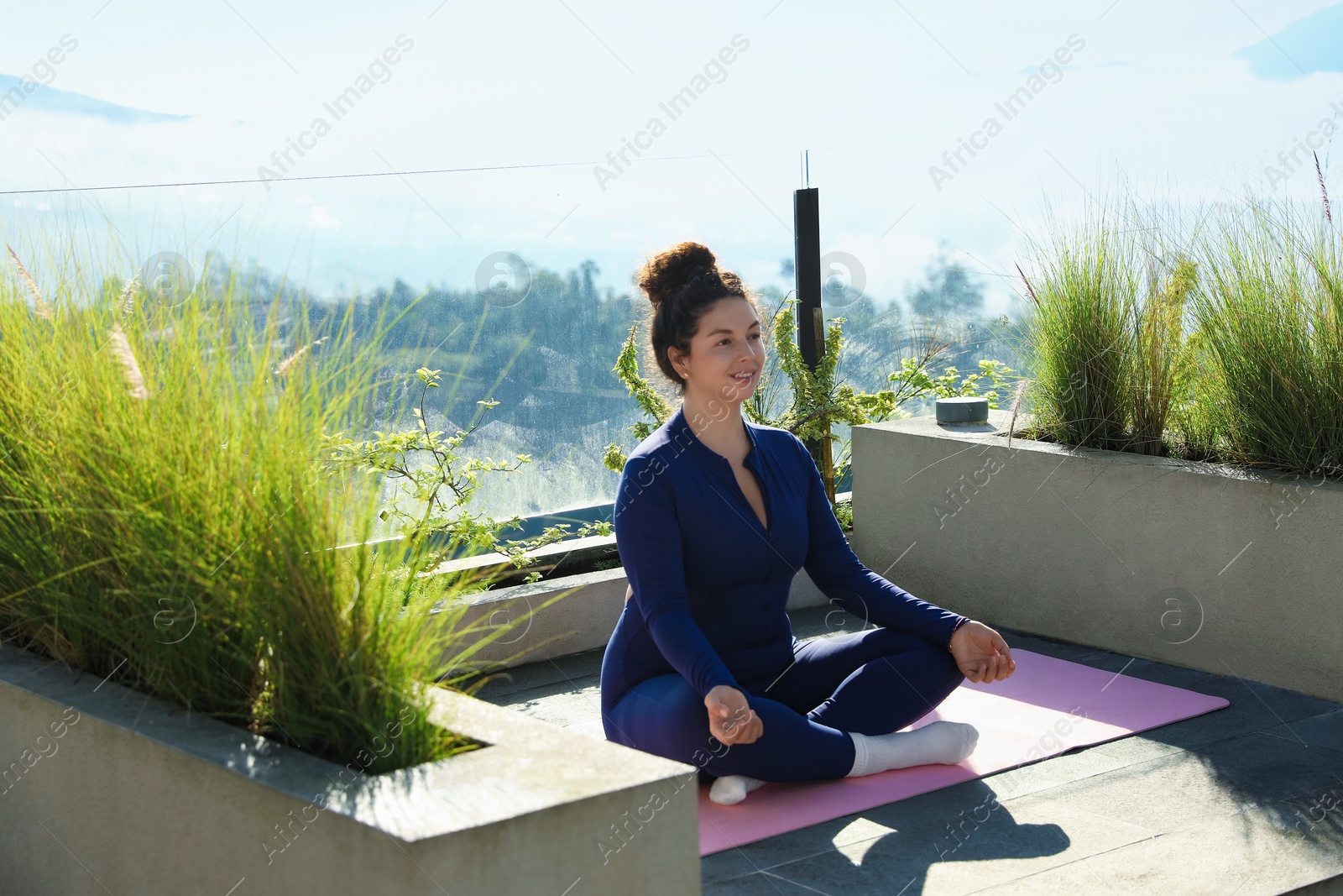 Woman meditating on yoga mat at balcony Photo of Woman meditating on yoga mat at balcony