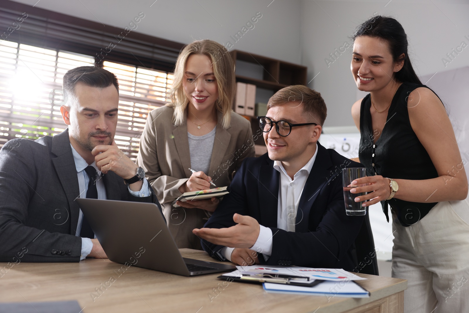 Photo of Marketing. Team of businesspeople working together at desk in office