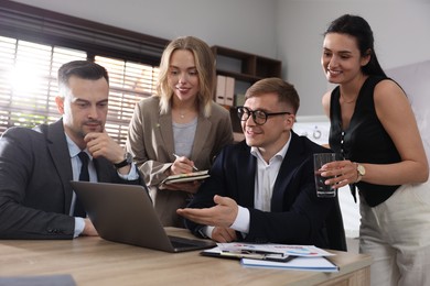 Photo of Marketing. Team of businesspeople working together at desk in office