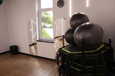 Photo of Different sports equipment and mirrors in fitness studio
