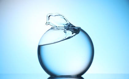 Photo of Glass aquarium with water on light blue background