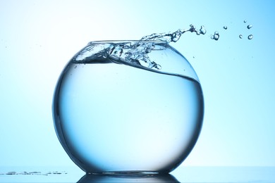 Photo of Glass aquarium with water on light blue background