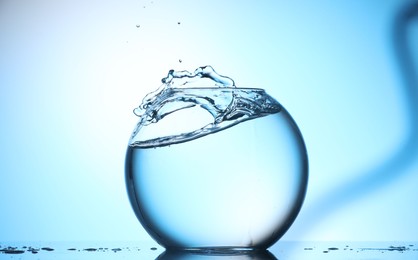 Photo of Glass aquarium with water on light blue background