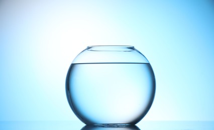 Photo of Glass aquarium with water on light blue background