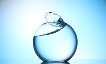 Photo of Glass aquarium with water on light blue background