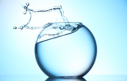 Photo of Glass aquarium with water on light blue background